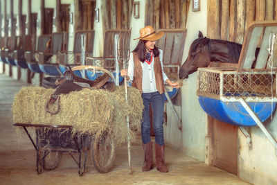 Woman in traditional clothing standing by barn