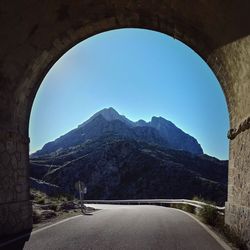 Road by mountains against clear sky