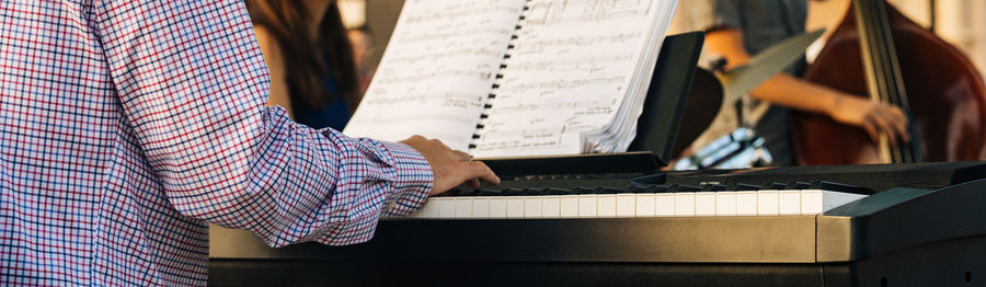 Midsection of man playing piano
