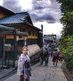 People walking on street against buildings in city