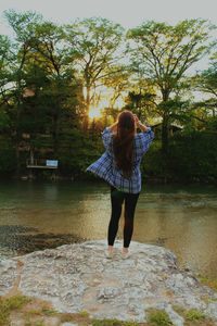 Rear view of woman standing at lakeshore