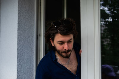 Portrait of man standing by window