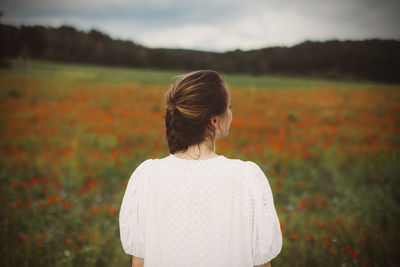 Rear view of woman standing on field