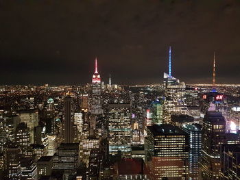 Illuminated cityscape against sky at night