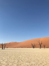 Scenic view of desert against clear blue sky