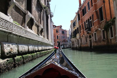 Boats in canal amidst buildings in city