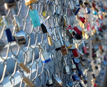 Padlocks hanging on chainlink fence