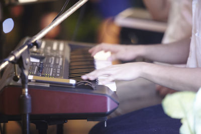 Cropped hands of person playing piano