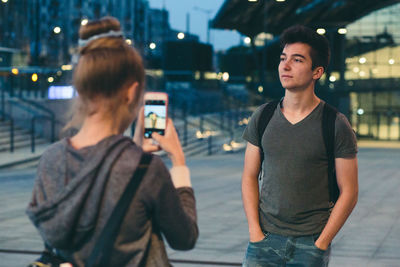 Full length of man photographing while standing on street in city