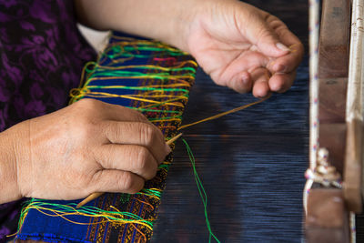 Midsection of woman weaving