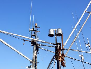 Low angle view of electricity pylon against clear blue sky