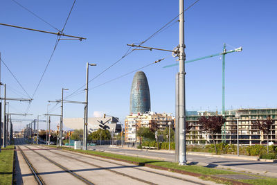 Street and buildings against clear blue sky