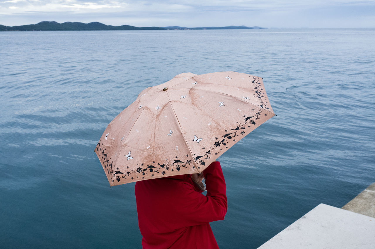 WOMAN WITH UMBRELLA ON SEA