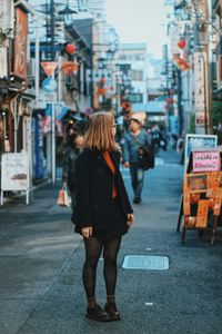 Rear view of woman walking on city street