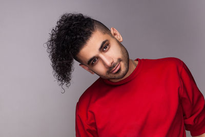 Young man looking away against wall