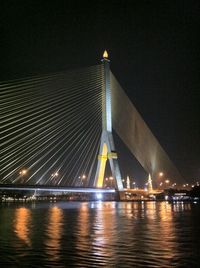 Suspension bridge over river at night