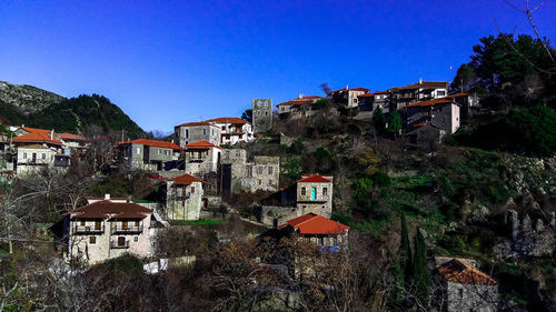 Buildings in city against clear blue sky