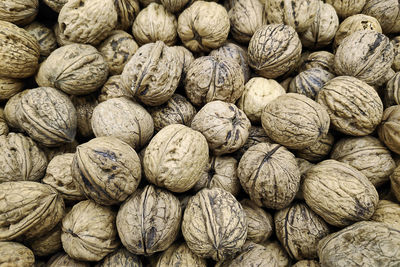 Close-up on a stack of walnuts on a market stall.
