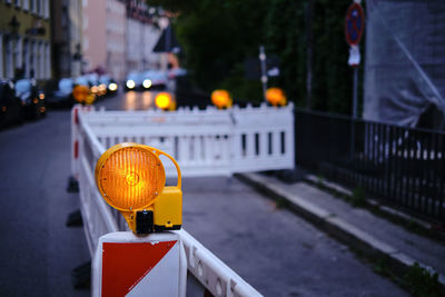 Yellow lights on street by railing in city