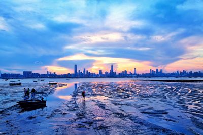 City at waterfront during sunset