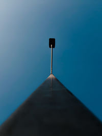 Low angle view of electric lamp against blue sky