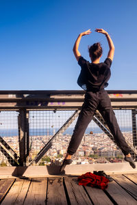 Rear view of man standing at observation point against clear sky