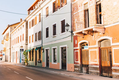 Road by buildings in city against sky