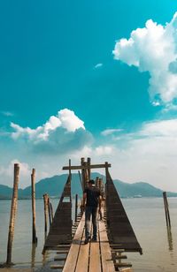 People standing on pier over sea against sky