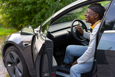 Portrait of young woman sitting in car