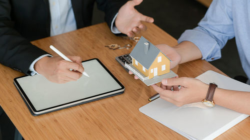 High angle view of people holding hands on table