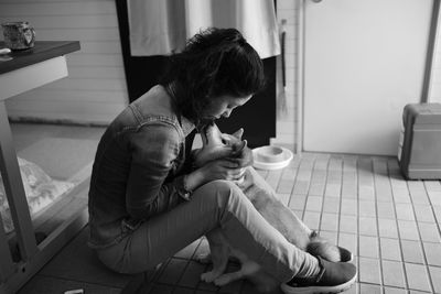 Woman playing with dog at home