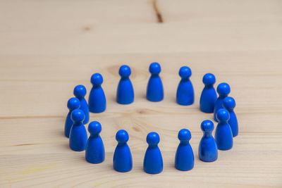 Close-up of blue figurines arranged on wooden table