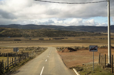 Road by mountains against sky