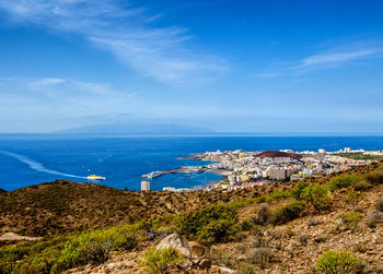 Scenic view of sea and townscape against sky