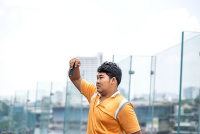 Man taking selfie against clear sky in city