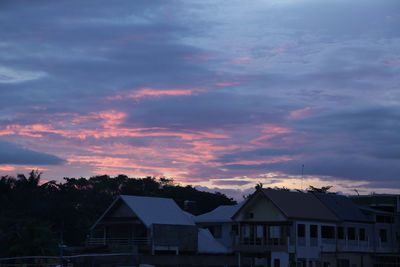 Houses and buildings against sky at sunset