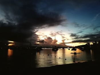 Silhouette boats in sea against sky during sunset