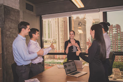 Colleagues gesturing during meeting in board room