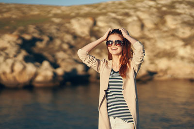 Portrait of young woman wearing sunglasses standing outdoors