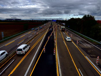 High angle view of traffic on highways against cloudy sky