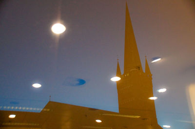 Low angle view of illuminated lighting equipment at night