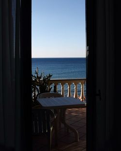 Scenic view of beach against sky seen through window