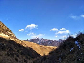 Scenic view of mountains against blue sky