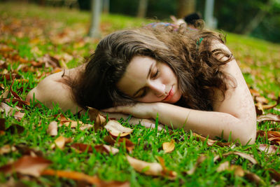Teenage girl lying on field at park