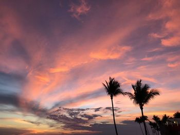 Low angle view of silhouette palm trees against romantic sky