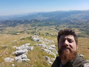 Portrait of man on mountain against sky