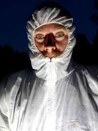 Portrait of man wearing raincoat against black background