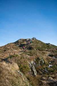 People on landscape against clear sky