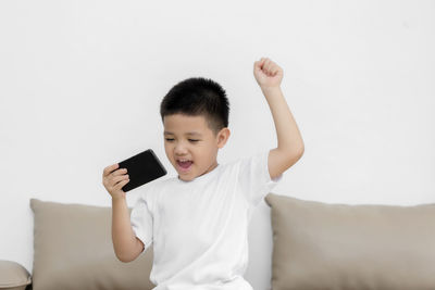 Rear view of boy using mobile phone