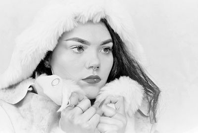 Young woman in warm clothes against white background